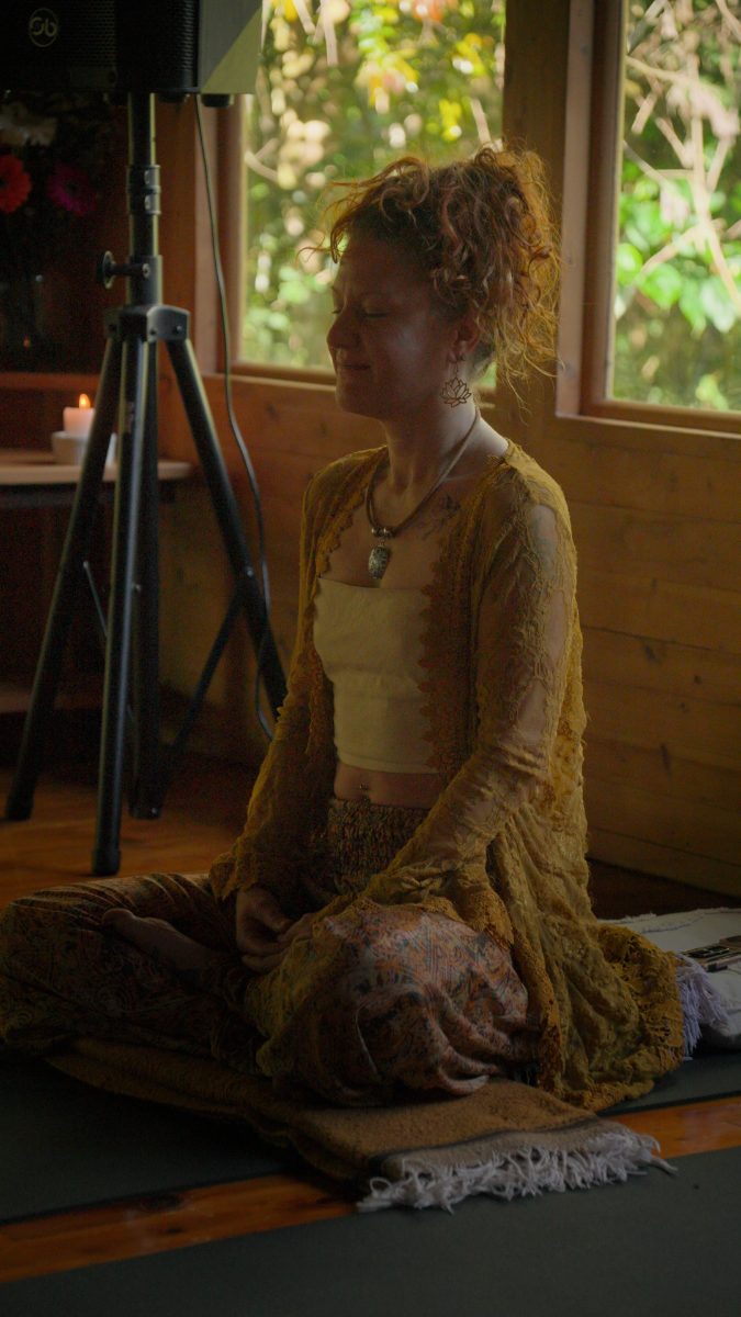 A guest seated in ceremony inside the wooden shala